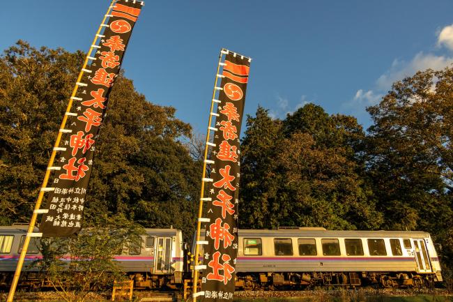 下り列車と神社の幟旗