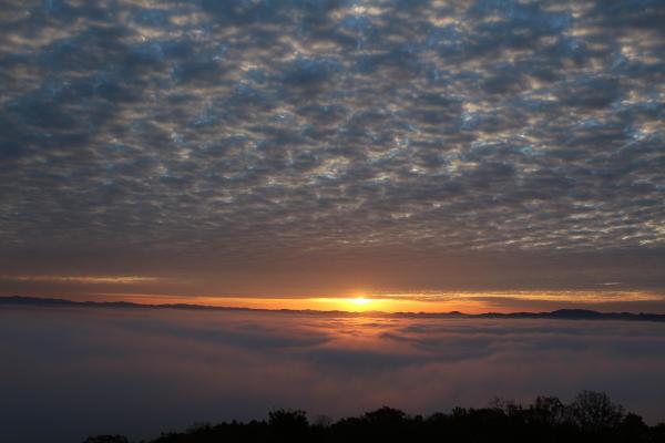 霧の海と雲との間から朝日